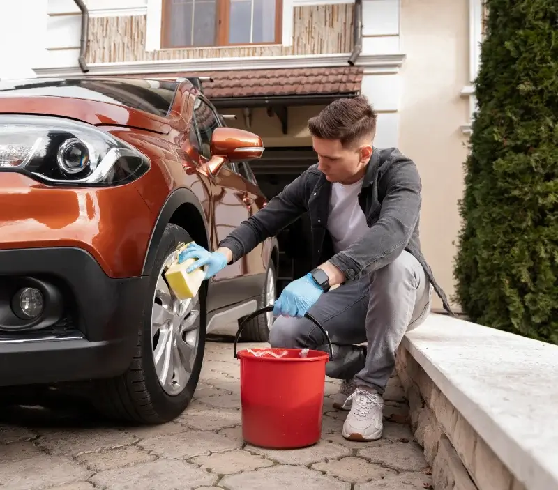 Lavage auto à domicile Les Roches-l'Évêque : professionnel intervenant sur un véhicule